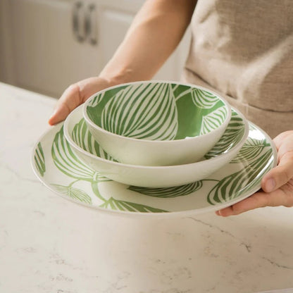 Holding Place Setting Dishes With Tropical Leaf Patterns Ceramic Bowls And Plate In Leafy Green Pattern